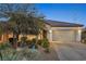 Exterior elevation showcasing desert landscaping, and a paved driveway leading to the attached two-car garage at 7148 Stanley Frederick St, Las Vegas, NV 89166