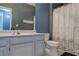 Bathroom with neutral-toned vanity, mirror, and toilet, with a bathtub and patterned shower curtain at 7155 S Durango Dr # 303, Las Vegas, NV 89113
