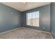 Empty bedroom with neutral carpet and large window, offering lots of natural light at 7155 S Durango Dr # 303, Las Vegas, NV 89113