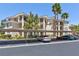 Attractive condominium complex with covered parking, mature landscaping, and palm trees on a beautiful sunny day at 7155 S Durango Dr # 303, Las Vegas, NV 89113