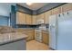 View of bright kitchen with white appliances, neutral granite countertops, and light wood cabinetry at 7155 S Durango Dr # 303, Las Vegas, NV 89113