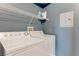 Functional laundry area includes modern appliances and a wire rack shelf, optimizing space at 7155 S Durango Dr # 303, Las Vegas, NV 89113