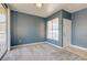 Empty living room with fresh paint, new carpeting, and a sliding glass door leading to a patio at 7155 S Durango Dr # 303, Las Vegas, NV 89113