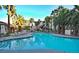 Large sparkling outdoor pool with lounge chairs, towering palm trees, and meticulously landscaped grounds at 7155 S Durango Dr # 303, Las Vegas, NV 89113
