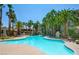 Large sparkling outdoor pool with lounge chairs and towering palm trees, perfect for relaxation at 7155 S Durango Dr # 303, Las Vegas, NV 89113