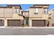 Modern townhome featuring a two-car garage, desert landscaping and a vibrant teal-colored front door at 752 Echelon St, Las Vegas, NV 89138