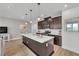 Spacious kitchen with dark wood cabinets, modern appliances, an island with seating and hardwood floors at 752 Echelon St, Las Vegas, NV 89138