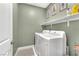 Bright laundry room with white washer and dryer, an overhead shelf and light green paint at 752 Echelon St, Las Vegas, NV 89138