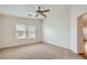 Bedroom with neutral carpet and two windows, providing natural light and a view of the neighborhood at 8787 Roping Rodeo Ave # 101, Las Vegas, NV 89178