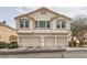 Two-story stucco townhouse with three garages and well-maintained landscaping at 8787 Roping Rodeo Ave # 101, Las Vegas, NV 89178