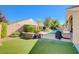 Private backyard featuring artificial turf, a built-in BBQ, and mature landscaping for outdoor living at 9108 Tuxpan St, Las Vegas, NV 89131