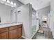 Bathroom with dual sinks, marble countertops, glass shower, and hardwood floors at 9108 Tuxpan St, Las Vegas, NV 89131