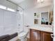 Clean bathroom with shower over tub, large mirror, modern vanity, and window for natural light at 9108 Tuxpan St, Las Vegas, NV 89131