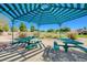 Shaded picnic area features three tables, a grill, and patterned shade structure at 9108 Tuxpan St, Las Vegas, NV 89131