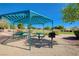 A bright, airy picnic area features multiple tables, a grill, and lush landscaping at 9108 Tuxpan St, Las Vegas, NV 89131