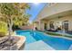 Beautiful backyard pool with a lush green tree and covered patio, perfect for relaxation at 9108 Tuxpan St, Las Vegas, NV 89131