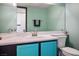 Bathroom with turquoise vanity, white sink, and large mirror at 938 Carnival Ave, Las Vegas, NV 89123