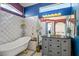 Charming bathroom with a clawfoot tub, white tile, unique vintage vanity and colorful accent walls at 938 Carnival Ave, Las Vegas, NV 89123