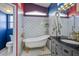 Charming bathroom featuring a clawfoot tub, walk-in shower, vintage vanity, and colorful accent walls at 938 Carnival Ave, Las Vegas, NV 89123