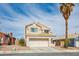 Two-story home featuring a two-car garage, desert landscaping and a beige stucco exterior at 938 Carnival Ave, Las Vegas, NV 89123