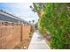 Exterior walkway with brick wall, lush greenery, and mature trees at 938 Carnival Ave, Las Vegas, NV 89123