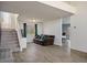 Open concept living room with tile flooring, stairs and views into the dining area at 938 Carnival Ave, Las Vegas, NV 89123
