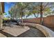 Backyard view showcasing a curved stone wall, mature trees, and brick perimeter wall at 9485 Parkmoor Ave, Las Vegas, NV 89149