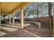 Backyard view showcasing a covered patio, stone bench seating and mature shade trees at 9485 Parkmoor Ave, Las Vegas, NV 89149