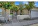 Inviting front entrance with stone accents, decorative trees, and a charming courtyard gate at 9485 Parkmoor Ave, Las Vegas, NV 89149