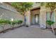 Charming home entrance with stone pillars, a decorative glass door, and manicured landscaping at 9485 Parkmoor Ave, Las Vegas, NV 89149