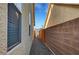 Side yard view of pathway, brick wall, and lush desert landscaping around perimeter at 9485 Parkmoor Ave, Las Vegas, NV 89149