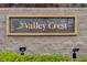 Elegant Valley Crest community signage with brick facade and manicured greenery in front at 9485 Parkmoor Ave, Las Vegas, NV 89149