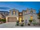 Charming two-story home with a well-manicured lawn and inviting curb appeal at dusk at 1004 Bluebird Ridge Ct, North Las Vegas, NV 89084