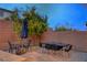 Outdoor dining set in a private backyard with a brick wall and lush landscaping at 1004 Bluebird Ridge Ct, North Las Vegas, NV 89084