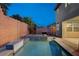 Relaxing pool area surrounded by a brick wall and lush greenery, creating a private backyard oasis at 1004 Bluebird Ridge Ct, North Las Vegas, NV 89084