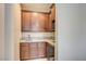 Charming wet bar with granite countertops, wood cabinetry, and a built-in wine fridge at 1004 Bluebird Ridge Ct, North Las Vegas, NV 89084