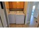 Convenient laundry room features a washer, dryer and oak cabinets for ample storage at 1016 Vantage Point Rd, Las Vegas, NV 89128