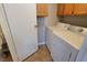 Convenient laundry room features a washer, dryer and oak cabinets for ample storage at 1016 Vantage Point Rd, Las Vegas, NV 89128
