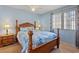 Bedroom featuring wooden bed frame with patterned bedding, side tables with lamps, and bright, natural light at 2040 Willowbury Dr # A, Las Vegas, NV 89108