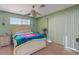 Cozy bedroom with light green walls, a ceiling fan, and a comfortable bed with colorful accents at 2040 Willowbury Dr # A, Las Vegas, NV 89108