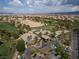 An aerial view of the golf course with lush green fairways, palm trees and community buildings at 21 Ocean Harbour Ln, Las Vegas, NV 89148