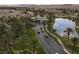 Aerial view of the gated entrance to a community, showcasing meticulously maintained landscaping and a serene lake at 21 Ocean Harbour Ln, Las Vegas, NV 89148