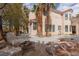 A well maintained backyard with a stone waterfall feature, seating, and lush palm trees offering a private retreat at 21 Ocean Harbour Ln, Las Vegas, NV 89148