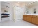 Well-appointed bathroom with a modern shower and vanity with wooden cabinets, door leading to main bedroom at 21 Ocean Harbour Ln, Las Vegas, NV 89148