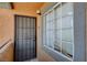 Apartment front door with security screen next to large window with privacy blinds at 220 Mission Catalina Ln # 207, Las Vegas, NV 89107