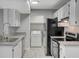 Well lit kitchen featuring stainless steel appliances, light grey counter tops, and a view of the laundry room at 220 Mission Catalina Ln # 207, Las Vegas, NV 89107