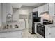 Well lit kitchen featuring stainless steel appliances, light grey counter tops, and a view of the laundry room at 220 Mission Catalina Ln # 207, Las Vegas, NV 89107