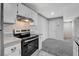 Well lit kitchen featuring stainless steel appliances, light grey counter tops, and a view to the living room at 220 Mission Catalina Ln # 207, Las Vegas, NV 89107