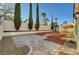 Spacious backyard with decorative rock, mature trees, and a covered patio, offering a serene outdoor retreat at 2221 Loggerhead Rd, Las Vegas, NV 89117