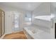 Well-lit bathroom with a soaking tub and shower with a white tile surround at 2221 Loggerhead Rd, Las Vegas, NV 89117